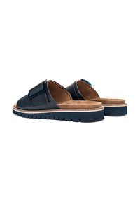 Navy blue leather slip-on shoes with a wide strap, padded insole, tan accents, and a textured rubber sole for grip.