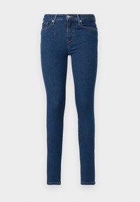 Smale bukser laget av mørkeblå denim. Har en tettsittende design, høy linning, fem lommer, og subtile oransje sømdetaljer.