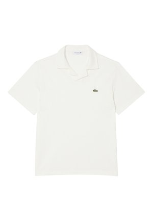 Witte polo met korte mouwen, een kraag en een klein groen krokodillenlogo op de linkerborst.