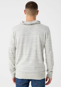 Sudadera con capucha de color gris claro con sutiles rayas texturizadas, dobladillo y puños acanalados, con un ajuste relajado y una capucha caída.