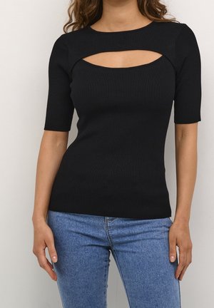 Frau trägt ein eng anliegendes schwarzes, geripptes Kurzarmtop mit Ausschnitt an der Brust, kombiniert mit hellblauen Denim-Jeans.