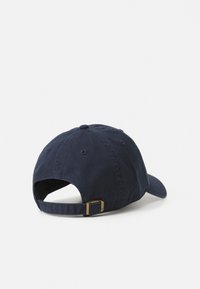 Marineblaue Baseballmütze aus Baumwolle mit gebogenem Schirm. Verfügt über einen Stoffriemen und eine Metallbuchse zur Anpassung. Strukturierter, langlebiger Stoff.