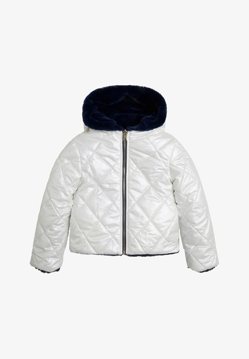 Doudoune matelassée blanche brillante avec capuche en fausse fourrure marine. Comprend une fermeture éclair frontale et un motif de couture diagonale.