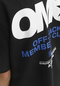 Juodas medvilninis marškinėliai su ryškiu baltu "VISA" tekstu ir mėlynomis detalėmis. Yra grafika "OFF-PACK NARĖ KLUBAS" ir papildomi prekės ženklo elementai.