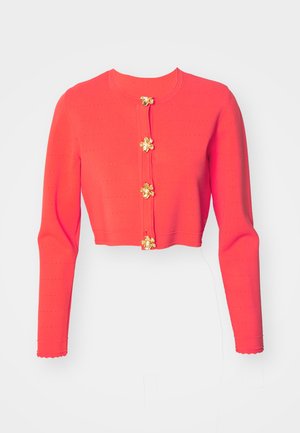 Kürzer geschnittene, langärmelige Strickjacke in leuchtendem Rot, mit goldenen Blumenknöpfen und strukturiertem Stoff mit horizontalen Linien und gewellten Bündchen.