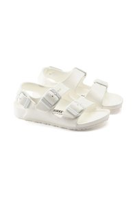 Białe sandały z regulowanymi paskami, wykonane z materiału syntetycznego. Posiadają klamry, otwartą konstrukcję oraz teksturowaną podeszwę dla lepszej przyczepności.