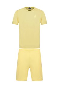 Conjunto de camiseta de algodón amarilla y pantalones cortos, con escote redondo, mangas cortas y detalle de logo grabado en el pecho izquierdo y en el muslo.