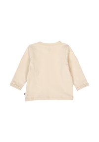 Cream long-sleeve top made from soft cotton, featuring a round neckline, stitched hems, and a small logo tag on the left side.
