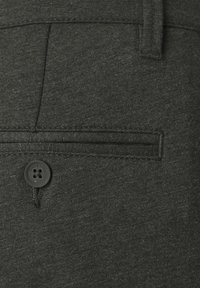 Tessuto grigio scuro di un paio di pantaloni con una tasca posteriore, dettagli di cucitura e un bottone nero con cinque fori, contrassegnato "ONLY & SONS."