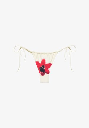Cremefarbener Bikinihose mit seitlichen Bändern und einem großen roten und schwarzen Blumenmuster in der vorderen Mitte.