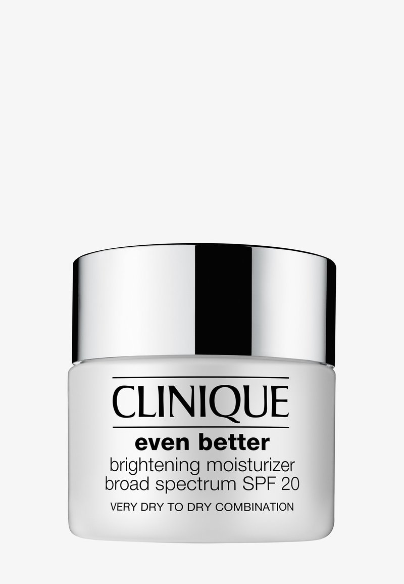 Crème hydratante éclaircissante Clinique Even Better dans un pot blanc avec un couvercle argent métallique, étiquetée pour une protection à large spectre FPS 20, pour peau sèche.