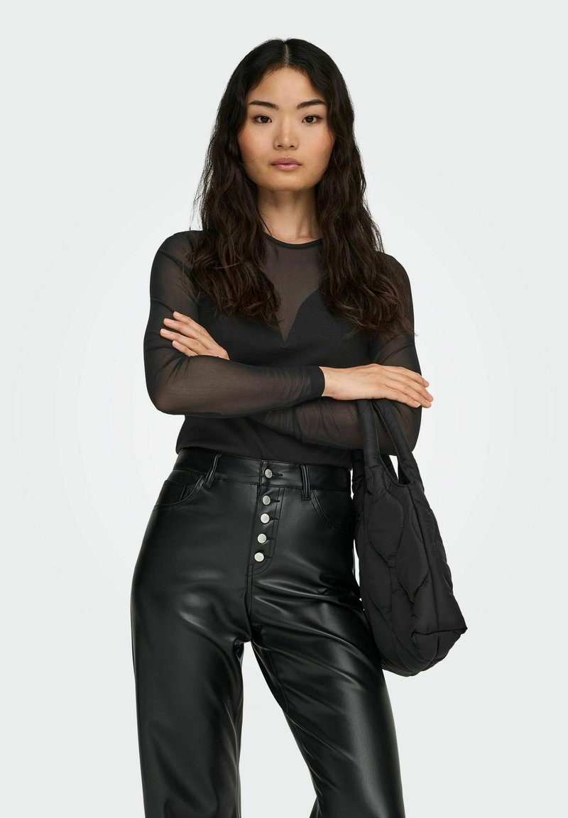 Black sheer long-sleeve top, high-neck design; paired with high-waisted black faux leather pants featuring front buttons. Holds a quilted black bag.
