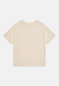 Beige tričko s krátkým rukávem a kulatým výstřihem, vyrobené z měkké tkaniny, s jednoduchým šitím a volným střihem.