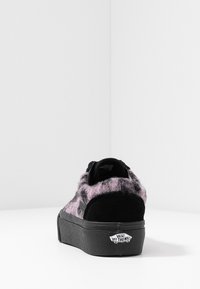 Schwarzer und pinker Sneaker mit einem flauschigen Textilobermaterial, texturierten Akzenten und einer klobigen schwarzen Gummisohle. Am hinteren Teil ist ein Vans-Logo zu sehen.