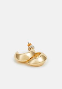Guldtonade metallörhängen med en böjd, blank yta och en �öppen design. Har en silverfärgad stift och orange gummibaksidan.