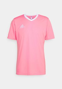Rosa tränings-T-shirt med korta ärmar, V-hals och vit krage. Har en broderad Adidas-logga på vänster bröst. Slät textur.