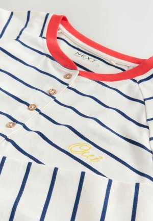 Bomullst-shirt med röd rund hals, marinblå och vita ränder, med dekorativa träknappar och gul "Oui"-broderi på framsidan.