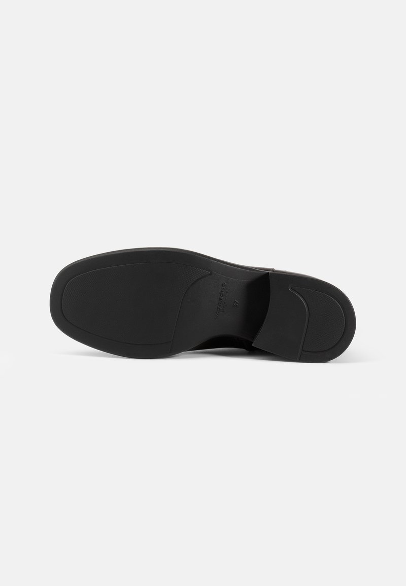 Black shoe sole with a smooth, textured grip, featuring a slightly raised heel and contoured shape. Clean design without embellishments.