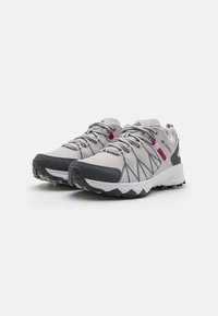 Zapatillas deportivas de color gris claro con parte superior de malla, detalles en gris oscuro, toques en rosa y una suela blanca texturizada con un patrón de dibujo resistente.