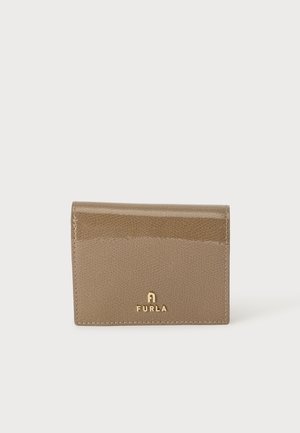 Taupe spalvos tekstūruotos odos Furla piniginė su auksiniu logotipu, įrėmintu priekyje ant šviesaus vientiso fono.