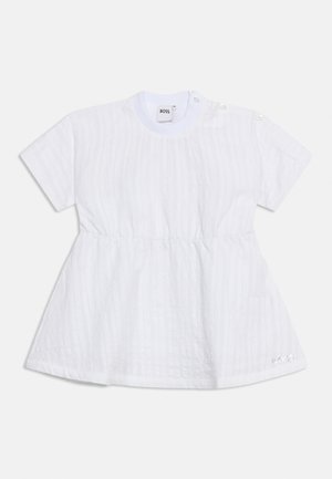 Hvit babykjole med korte ermer av teksturert stoff, innsvingt midje, rund hals, knapper på skuldrene og liten logo nær kanten.