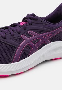 Chaussure de sport violette avec dessus en mesh, accents roses, semelle extérieure texturée et intermédiaire blanche contrastante. Comprend des lacets et un design de logo.