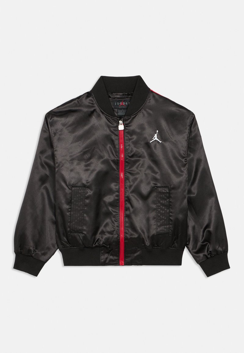 Casaco bomber em cetim preto com fecho de correr vermelho e detalhes, apresentando um colarinho canelado, punhos elásticos e um logótipo branco proeminente no peito.