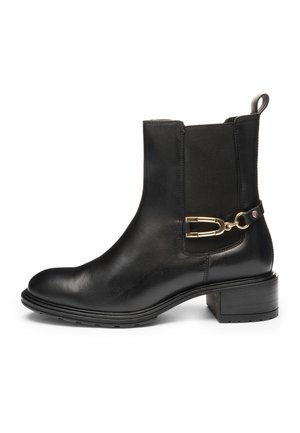 Schwarzer Leder-Stiefelette mit niedrigem Blockabsatz, elastischem seitlichem Einsatz und goldenem Metalldetail an der Außenseite.