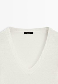 Maglione bianco a maglia con scollo a V, collo a coste e etichetta nera Massimo Dutti sulla parte posteriore del collo.