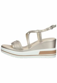 Sandales à semelle compensée avec une finition métallique brillante. Présentent une large bride et une bride de cheville ajustable. Semelle extérieure blanche avec une bande d'accent brun.