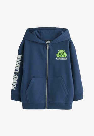 Sweat à capuche zippé bleu marine avec logo Star Wars Mandalorian et graphique de Baby Yoda sur la poitrine, et texte "MANDALORIAN" sur la manche gauche.
