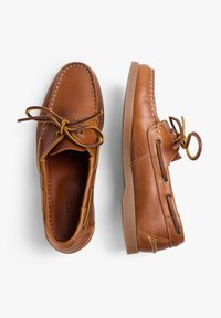 Bruine leren schoenen met een ronde neus, veters en decoratieve stiksels. Zijventilatie-oogjes en een rubberen zool zorgen voor stabiliteit en comfort.
