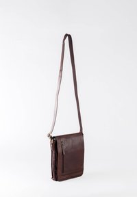 Brown leather crossbody bag with adjustable strap, front zipper pocket, smooth texture, and stitched accents. Compact and rectangular design.
