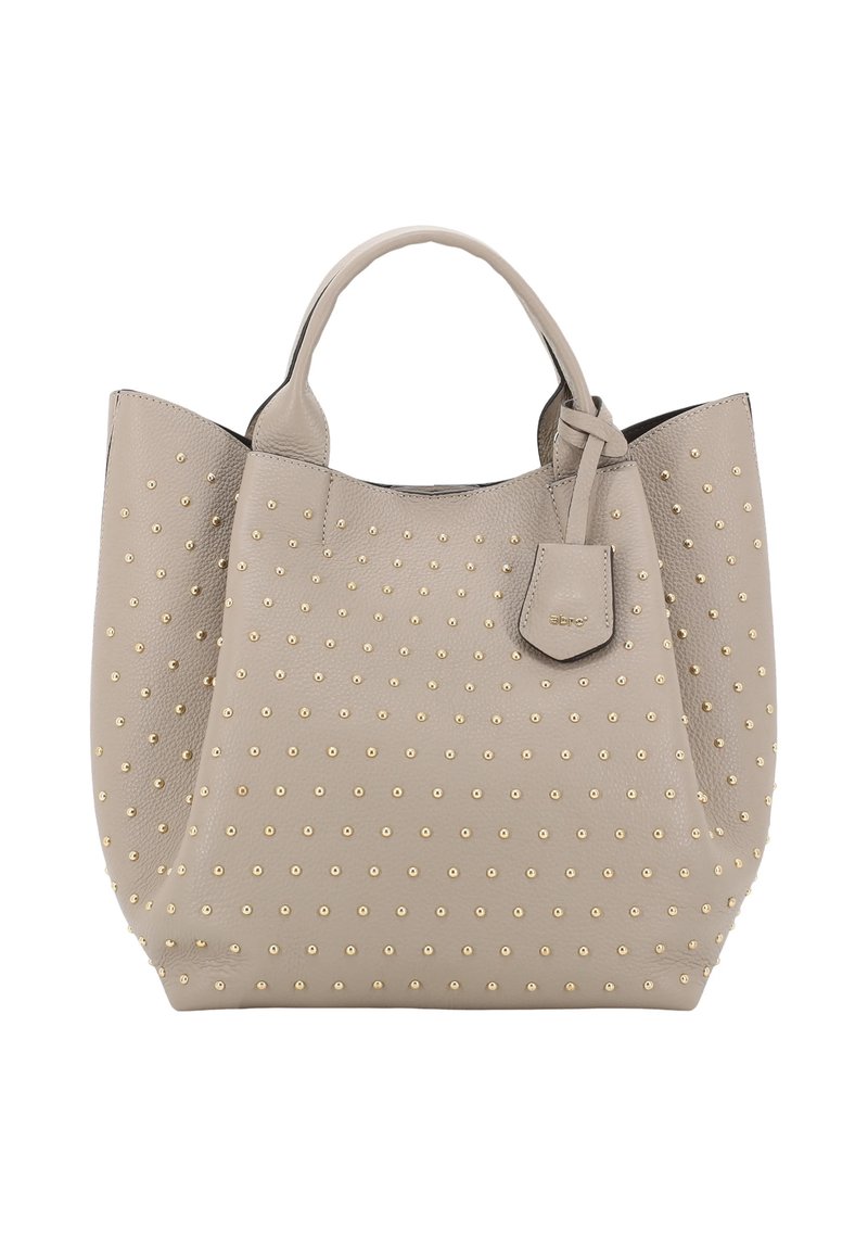 Sac fourre-tout en cuir beige avec des clous dorés, forme structurée, double anses et une petite étiquette détachable. Surface lisse.