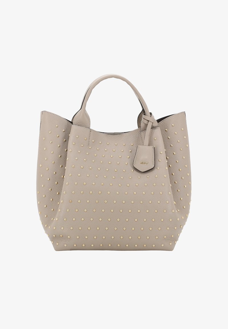 Sac fourre-tout en cuir beige avec des clous dorés, forme structurée, double anses et une petite étiquette détachable. Surface lisse.
