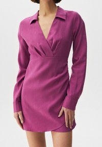 Fuksianpunainen pitkähihaista mekkoa, jossa on viistekaulus, kietaisusuunnittelu ja slim fit. Sileä kangas ja kaareva helma.