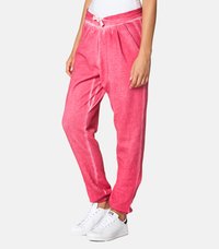 Roza, mehka trenirka z vrvico v pasu, zoženimi hlačnicami in stranskimi žepi. Tkanina ima subtilno teksturo in rahlo sijaj.