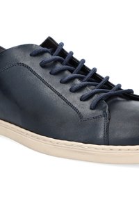 Granatowe skórzane buty z okrągłym noskiem, sześcioma otworami na sznurowadła i granatowymi sznurówkami. Posiadają kontrastującą jasną gumową podeszwę oraz gładką teksturę.