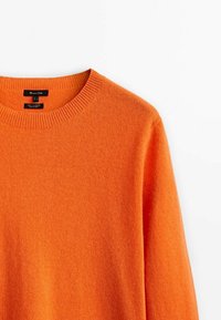 Pull en cachemire orange vif à col rond avec col côtelé, présenté sur fond blanc.