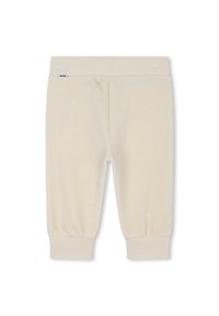 Pantaloni cropped di colore crema in un morbido tessuto a coste con cintura e polsini elasticizzati. Presentano un discreto etichetta di branding sulla cintura.