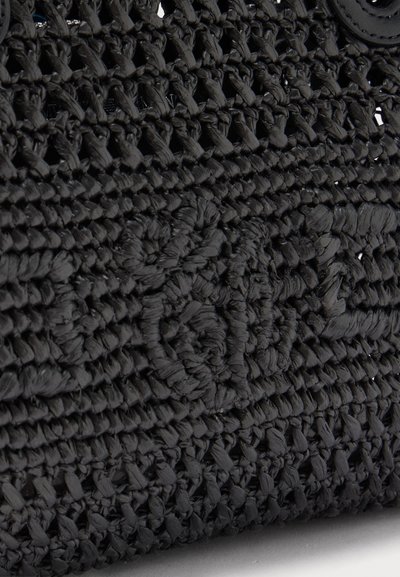 Κοντινό πλάνο υφής από σφιχτά υφαντό μαύρο άχυρο που παρουσιάζει περίπλοκα πλεγμένα και βρόχινα σχέδια.