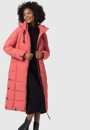 Long, puffy coral winter coat with a hood, featuring quilted patterns, adjustable drawstrings, and black accents. Worn over a black sweater dress.