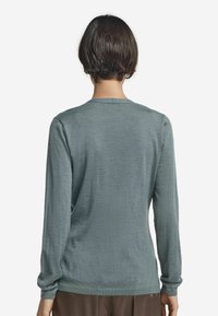 Lätt långärmad tröja i mjukt tealtyg, med rund halsringning och ribbade ärmslut, med en slät, strukturerad yta.