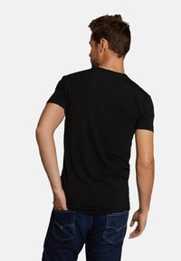 Zwarte T-shirt met korte mouwen, zichtbaar vanaf de achterkant, met een klassieke ronde hals en een gladde, lichte stoffen textuur.