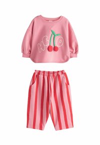 Pink cotton tracksuit featuring a long-sleeve top with "Hello" and cherry appliqué and pink striped pants with pockets.