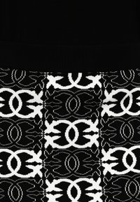 Peça de malha com a secção superior preta e a secção inferior com padrão de desenhos e formas geométricas brancas e pretas.