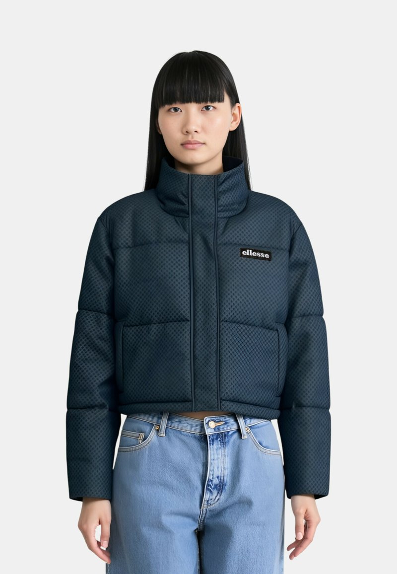 Giacca puffer trapuntata blu navy con alto colletto, due tasche frontali e patch con logo. Presenta una finitura testurizzata e una silhoutte cropped.
