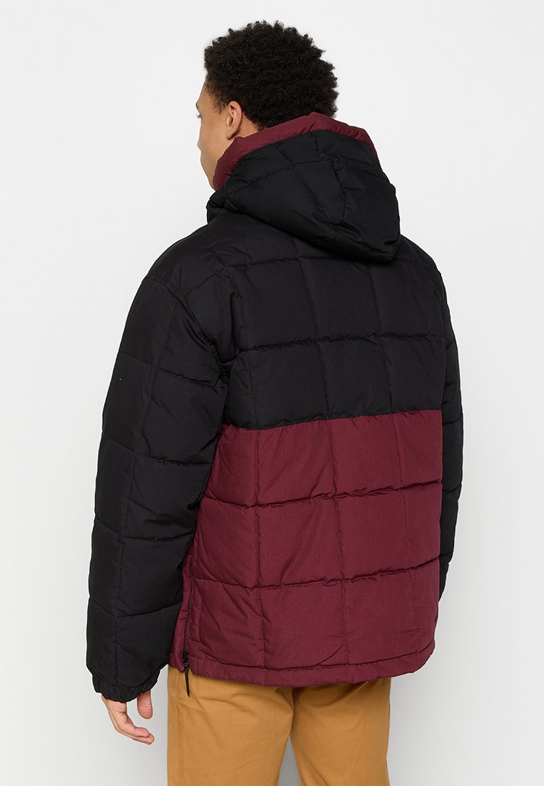 Czarna i bordowa kurtka puchowa z kapturem, z pikowanym wzorem i widocznymi szwami. Kieszenie na zamek błyskawiczny blisko dolnej krawędzi.