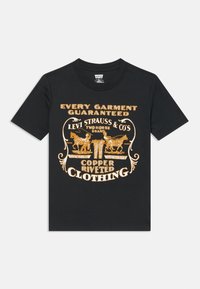 Čierne bavlnené tričko s vintage grafickým vzorom v zlatej farbe, na ktorom sú zobrazené texty a obrázky súvisiace s Levi Strauss & Co., vrátane dvoch jazdeckých postáv.