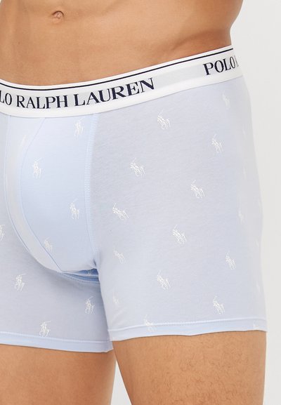Svijetloplave bokserice s rastezljivim pojasom na kojem je natpis "POLO RALPH LAUREN", ukrašene malim bijelim logotipima konja s igračem na tkanini.